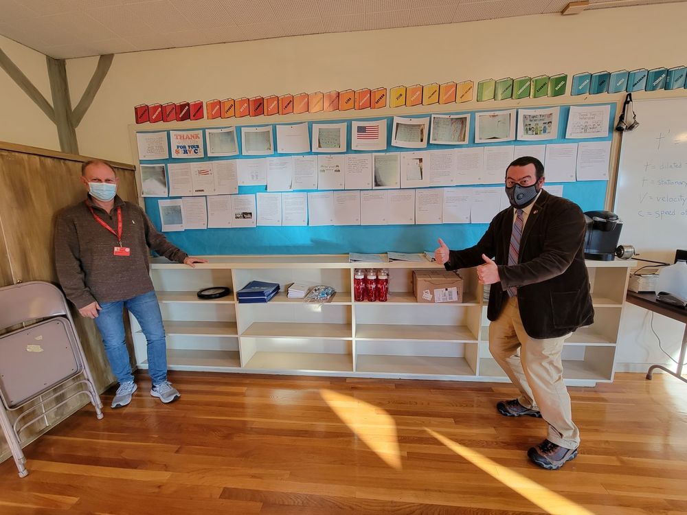 David Castonguay stands with Dr. Osborn in front of a bulletin board he put together with copies of the letters sent to veterans by WVS students.